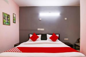 a bedroom with a large bed with red pillows at Hotel O Manya Stay in New Delhi
