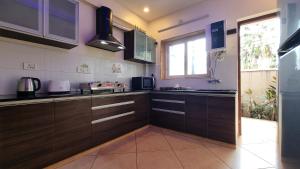 une cuisine avec des placards bruns et une fenêtre dans l'établissement Casa De Suenos - 3BHK Villa, Baga, à Arpora