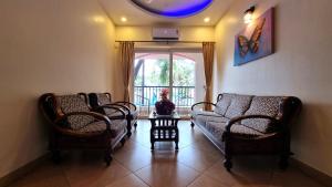 un salon avec un canapé, des chaises et une fenêtre dans l'établissement Casa De Suenos - 3BHK Villa, Baga, à Arpora