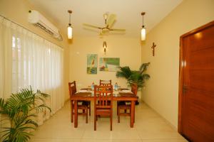 a dining room with a wooden table and chairs at Casa Das Imras Villa B in Calangute