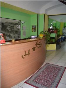 a counter in a restaurant with green walls at Hotel Stazione in Novara