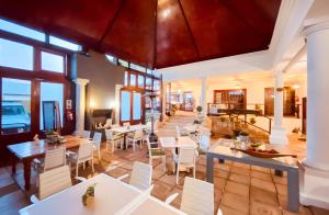 a restaurant with white tables and white chairs at Spacube Luxury Suites and Spa in Pretoria