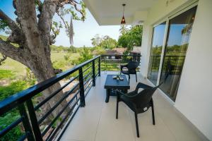 a balcony with a table and chairs and a tree at Casa Das Imras Villa B in Calangute