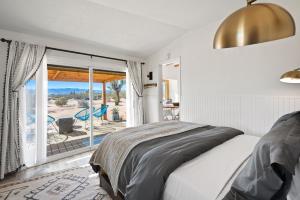 a bedroom with a bed and a view of the ocean at 2 Homes, Hot Tub, Firepit, BBQ, Games by MariamsBnb in Joshua Tree