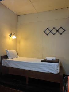 a bedroom with a bed with white sheets at Tata GuestHouse in Chiang Mai