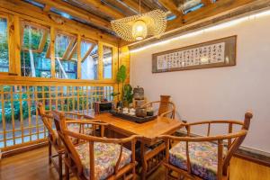a dining room with a wooden table and chairs at Lijiang Lights Quiet Garden Desinger SerenityHaven Hotel B&B Gucheng Zhongyi Mufu Branch in Lijiang