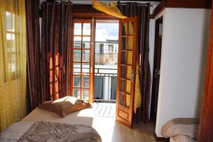 a bedroom with a bed and a door to a balcony at L'Habitation Firmant in Cilaos