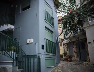 an apartment building with green doors and a staircase at D&D rooms Nafplio in Nafplio