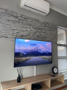 ein Flachbildfernseher, der an einer Wand hängt in der Unterkunft Grey Net in Palatswe