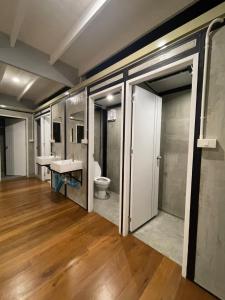 曼谷Green Cabin Hostel的带两个水槽和一个马桶的浴室