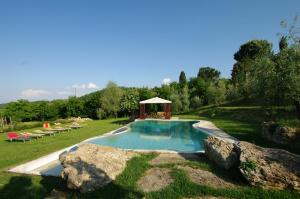 a swimming pool with a gazebo in a field at Agriturismo Ardene in Montepulciano