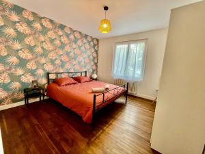 ein Schlafzimmer mit einem Bett mit Blumentapete in der Unterkunft La maison aux volets bleus in Pornic