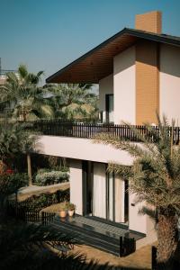 Un edificio con palmeras delante. en Villasita Resort, en Kankhal