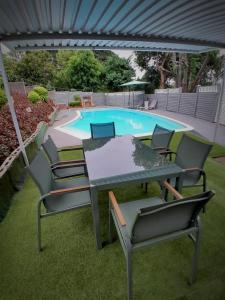 een tafel en stoelen voor het zwembad bij 54 Malcolm Palace Room in Durban +11 foto's