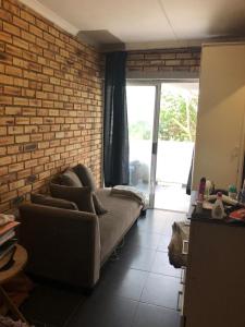 a living room with a couch and a brick wall at Tongaat beach holiday rental in Densainagar