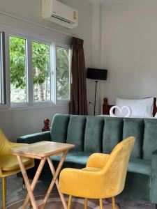 a living room with a green couch and chairs at SriThanu relaxing house 1 in Koh Phangan