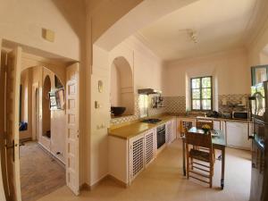 a large kitchen with a table and a counter top at Private Villa at Jardins de Touhina in Marrakesh
