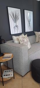 戈登湾V's Condo的客厅里一张灰色的沙发,有两张照片