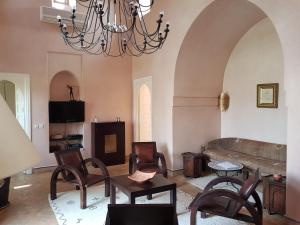 a living room with a couch and a chandelier at Private Villa at Jardins de Touhina in Marrakesh