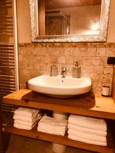 a bathroom with a sink and a mirror and towels at Maison Bovet Mont Blanc in La Salle