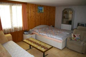 a bedroom with a bed and a chair and a table at BnB Villa Moncalme in Travers