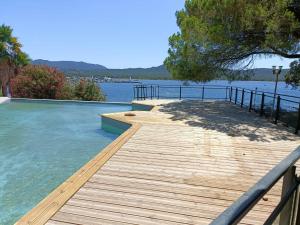 una terraza de madera con vistas al agua en Casa 115, en Pianottoli-Caldarello