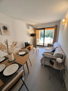 una sala de estar con una mesa y un sofá en Casa 115, en Pianottoli-Caldarello
