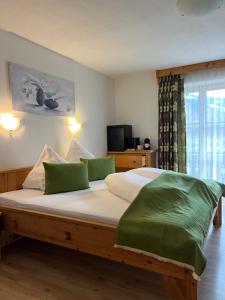 una camera da letto con un letto grande con cuscini verdi di Badererhof Christine Wechselberger a Stumm Altre 37 foto