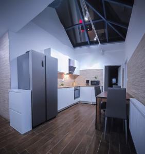 cocina con nevera grande y mesa en Sachsenheim Rooms & Apartments, en Sachsenheim
