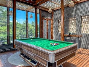a pool table in a room with windows at Foursons Villa in Denpasar