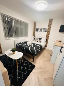 ein Schlafzimmer mit einem Bett und einem Tisch in einem Zimmer in der Unterkunft R3 - Luxury Private Room With its own Kitchenette in Halesowen in Hasbury + 15 Fotos