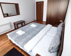 a white bed in a room with a mirror at "Mountain Dream" Apartments 200m from Ski Road in Bansko