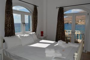 a bedroom with a bed with a view of the ocean at Maistrali in Sikinos