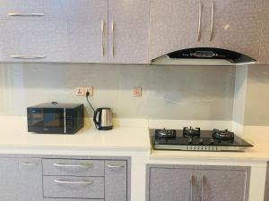 a kitchen with a stove and a microwave at Chiba Heritage Home in Pātan