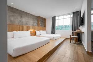 a hotel room with two beds and a window at The Bayou Hotel Langkawi in Pantai Cenang