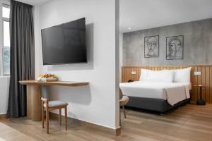 a hotel room with a bed and a flat screen tv at The Bayou Hotel Langkawi in Pantai Cenang