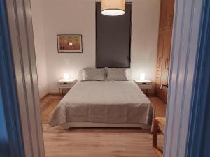 ein Schlafzimmer mit einem Bett und zwei Endtischen in der Unterkunft Vecchia Casa in Volos