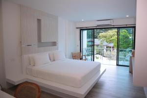 una camera da letto bianca con un letto e un balcone di Ton Sai Tropical Phi Phi Island a Phi Phi Don