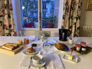 a table with a breakfast of bread and coffee and a window at Parc Monceau in Paris +7 photos