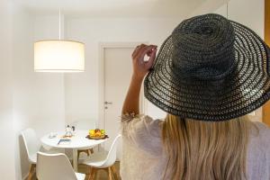 a woman is wearing a hat on her head at Costa Real - Garden Retreat with Private beach, Pet Friendly in Capo Vaticano