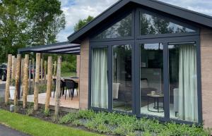 a small greenhouse with glass doors and a patio at Huisje in Dishoek in Koudekerke