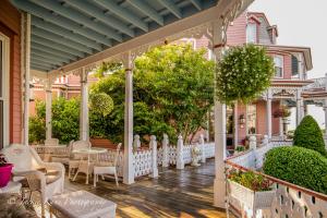 una veranda con sedie e tavoli su una casa di Angel of the Sea Bed and Breakfast a Cape May