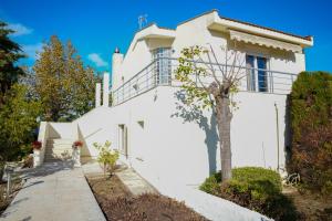 a white house with a tree in front of it at 2K Eco Villa in Plagiárion