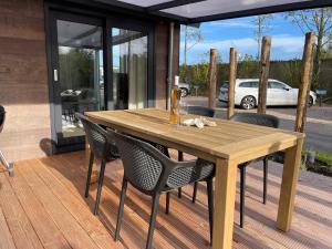 a wooden table and chairs on a deck at Huisje in Dishoek in Koudekerke