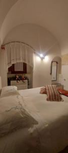 - une chambre avec un grand lit blanc à baldaquin dans l'établissement Casa Nonna Renzina, à Locorotondo