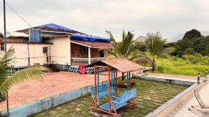 a house with a playground in front of it at Shantifarmstays in Pali +2 photos