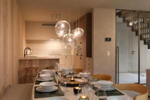 a dining room with a table with plates and glasses at Luxury Lodge with Jacuzzi for 8 – Woodz Lodges in Heusden - Zolder +72 photos