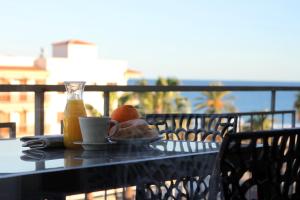 una mesa con una taza de café y un plato de comida en Apartamentos Cambrils Playa Spa, en Cambrils