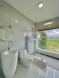 a bathroom with a toilet and a sink and a window at River valley resort แอทน่าน in Nan +263 photos