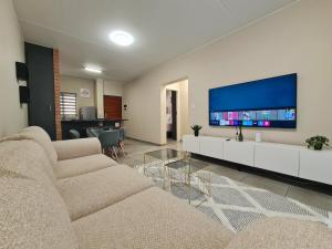 a living room with two couches and a flat screen tv at Ridge Comfort in Midrand